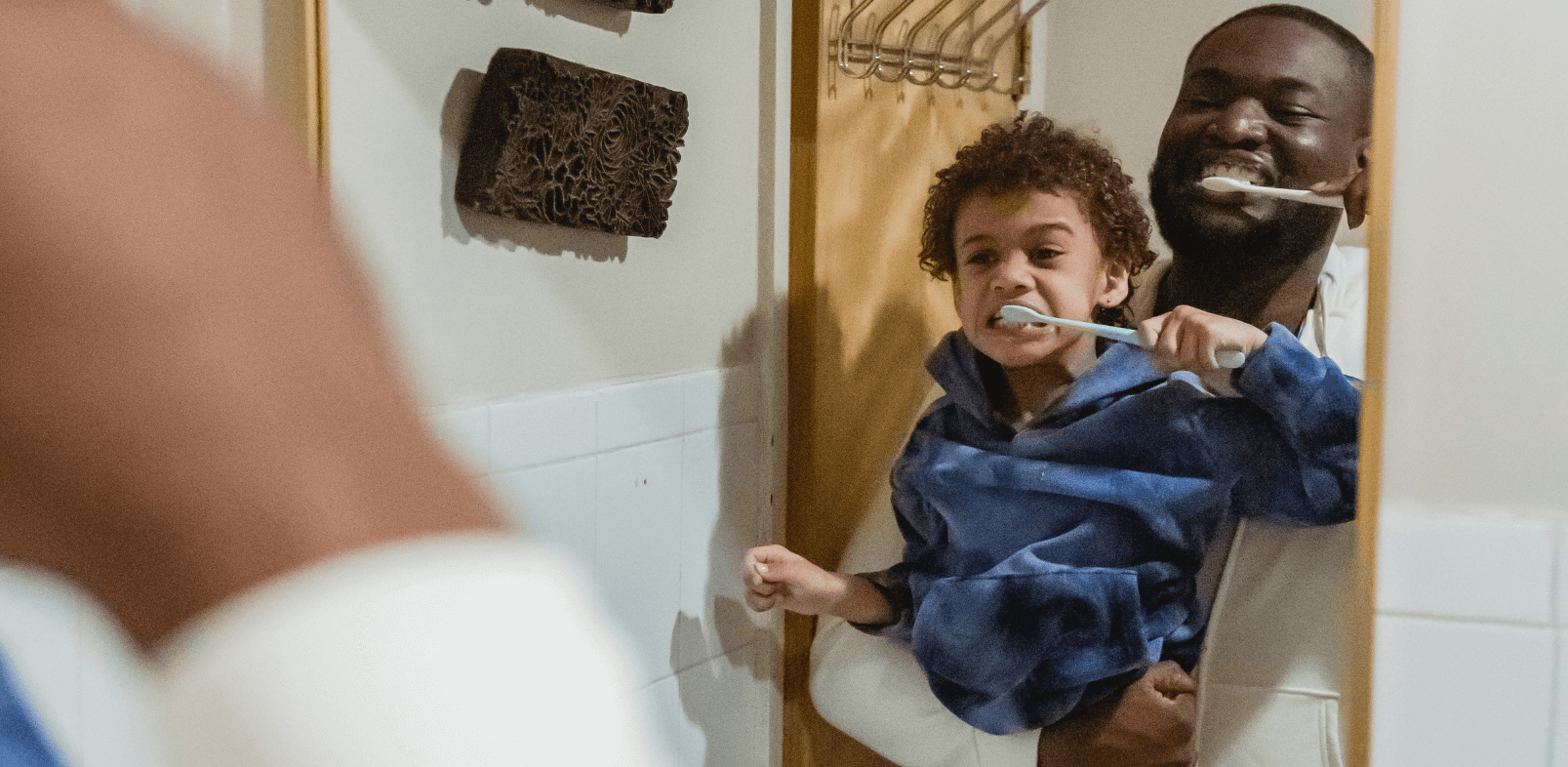 Father teaching child how to brush baby teeth