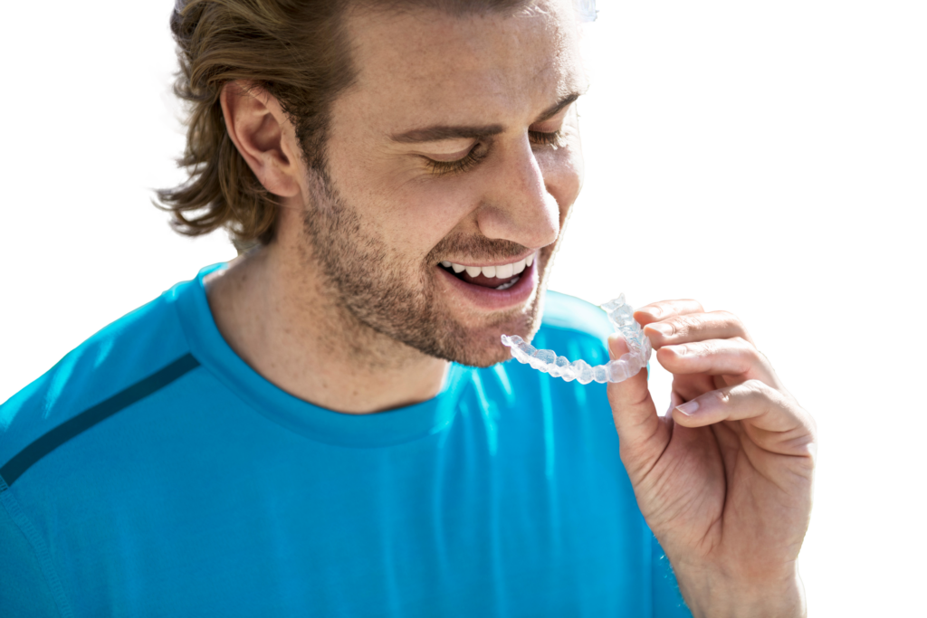 Man inserting Invisalign braces into mouth in Boroughbridge, Ripon